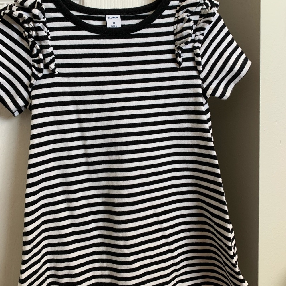 Black and white girls dress with ruffled shoulders.